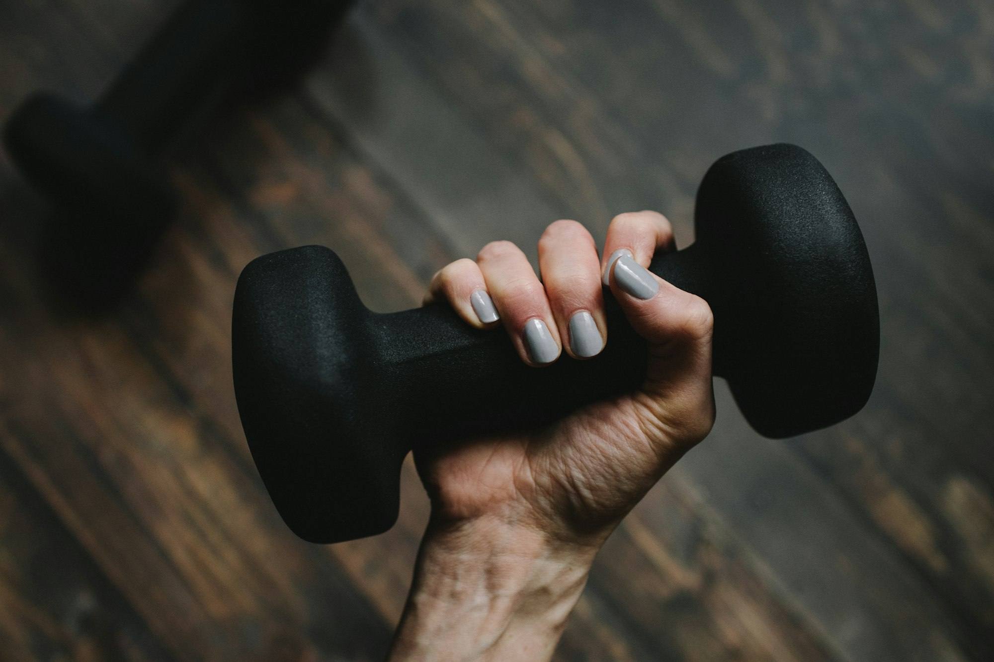 A hand gripping a black dumbbell